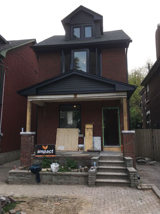 Brick house with front porch, new eavestrough, fascia and window capping during a renovation
